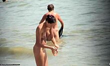 काले बालों वाली नंगी लड़की समुद्र तट पर नंगी घूमती हुई।