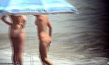 Tummatukkainen alaston poikasen kävely noin alasti rannalla